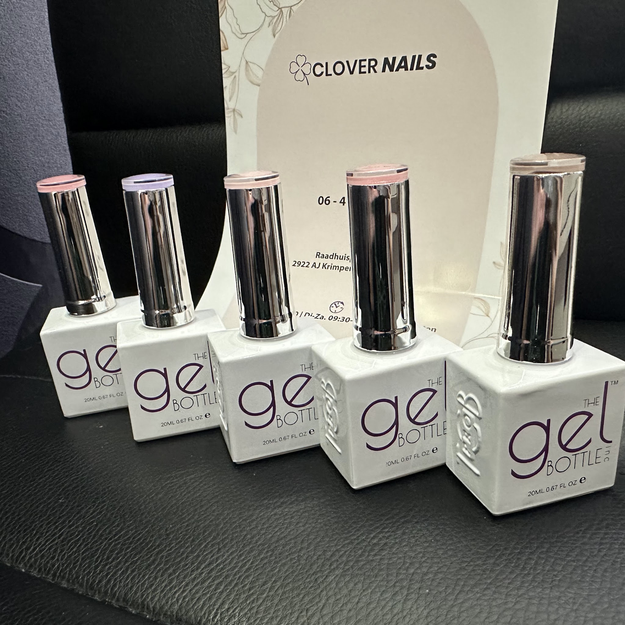 Flesjes gellak naast het naambordje van Clover Nails