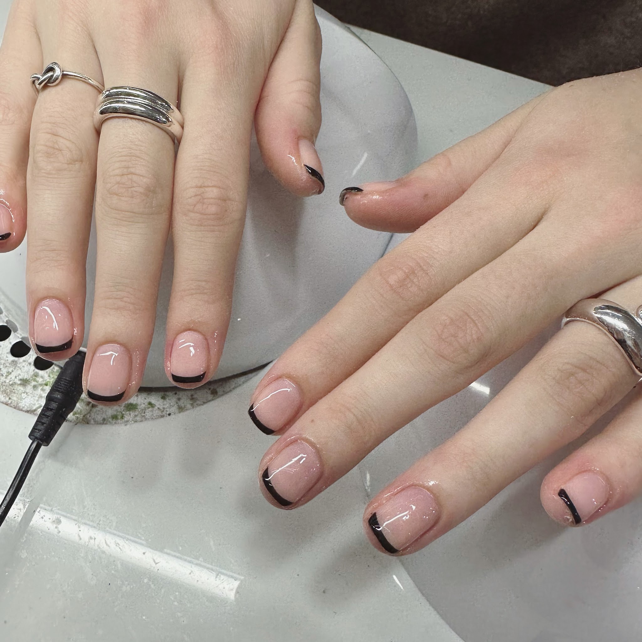 Korte nude nagels met zwarte french tips